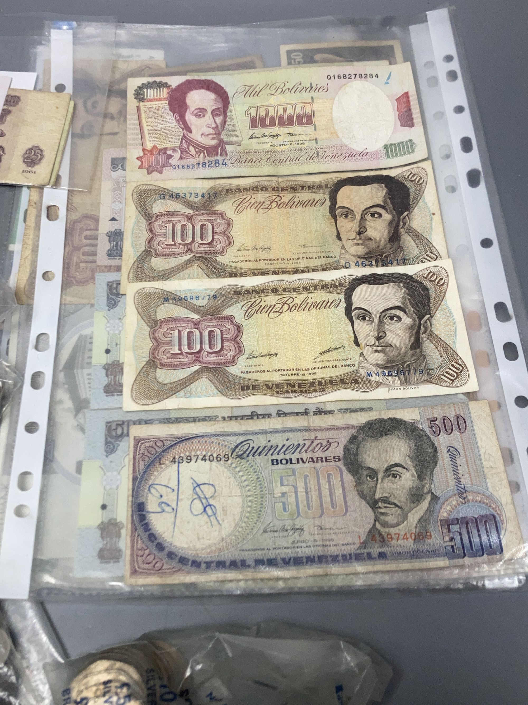 Various coins including Five Pounds coins and mixed world banknotes